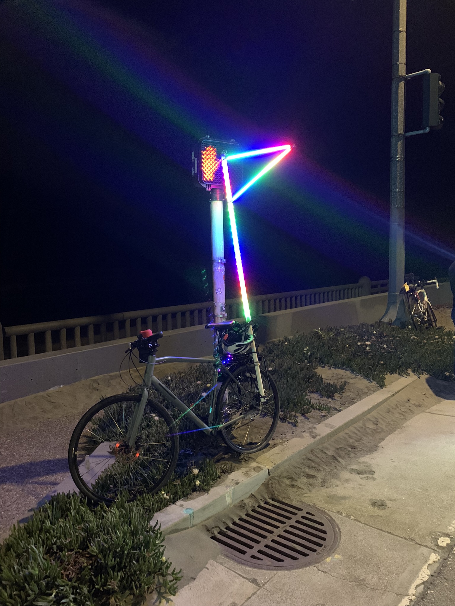 My raindbow bike flag leaning on a Great Walkway pedestrian signal.
