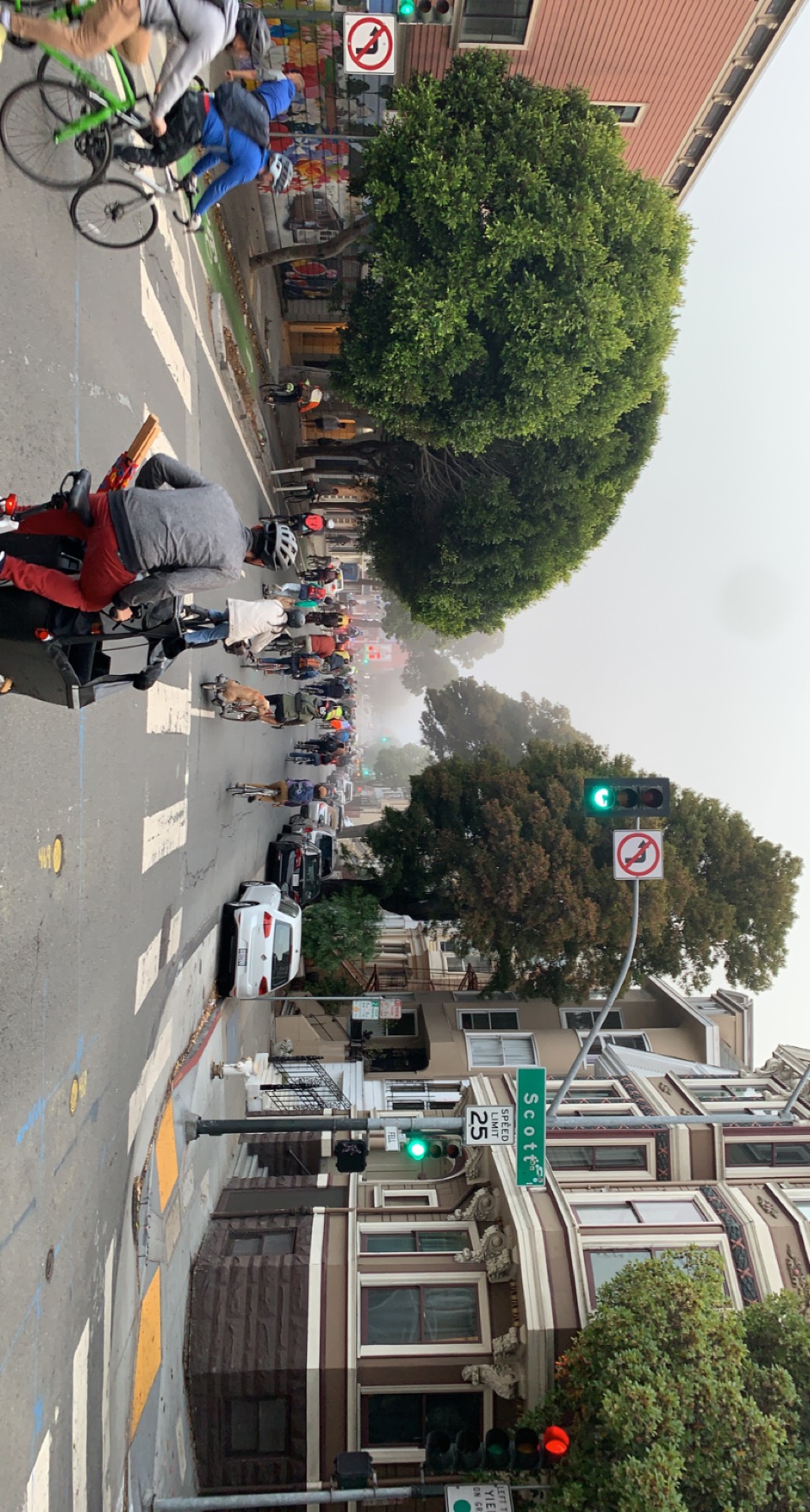 Dozens of bikes taking over the width of Fell at Scott St, with fog in the distance obscuring the view past Divisadero